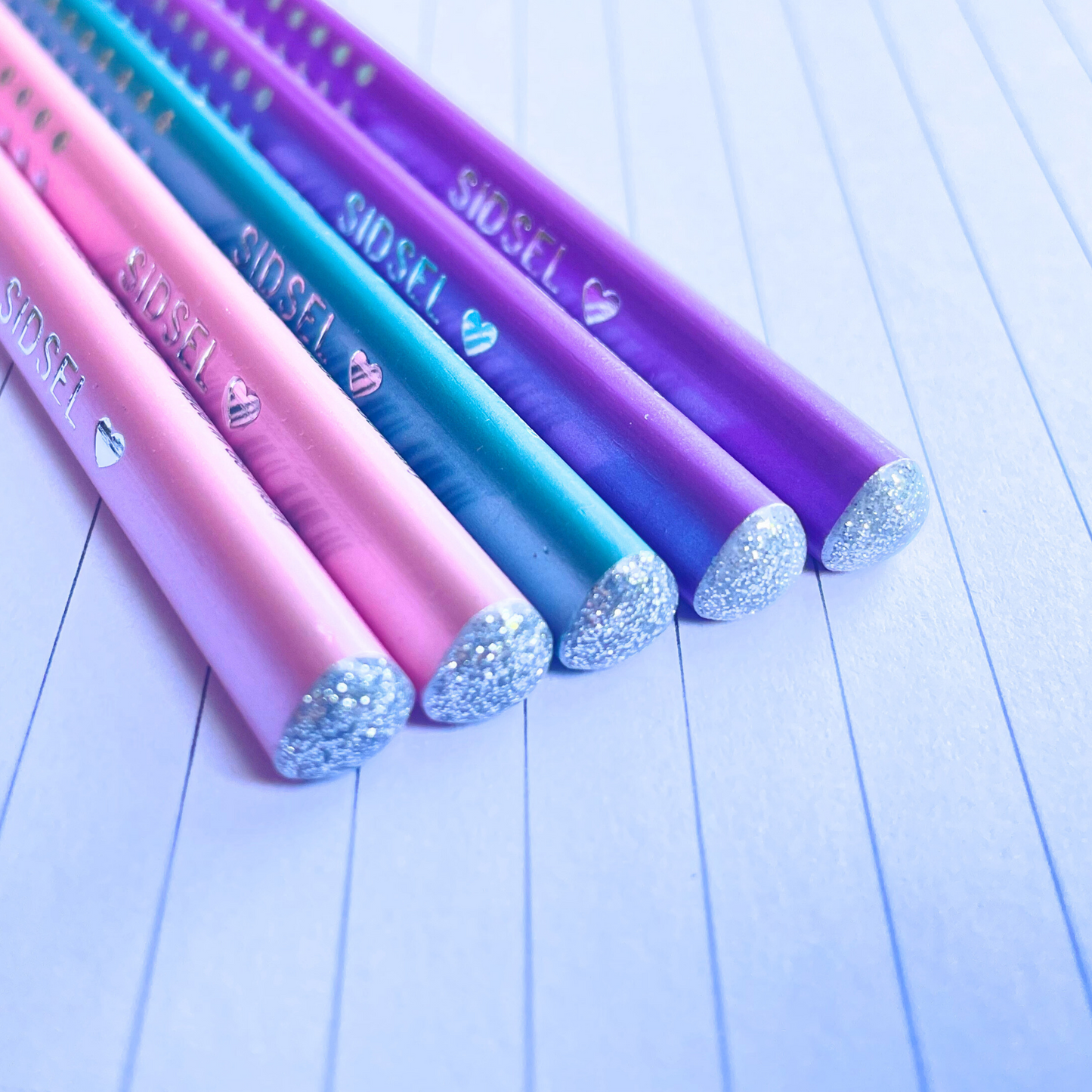 Close-up of the glittery ends and 'diamond' accents on the Faber-Castell Sparkle Edition pencil set in Ocean, Violet, and Rose.