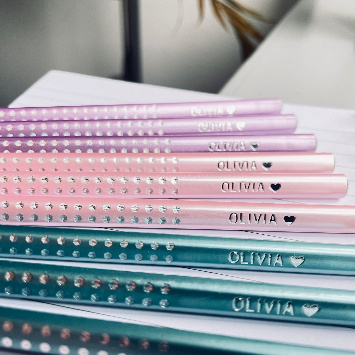 Assortment of Faber-Castell Sparkle Edition pencils with personalized name imprint, showcasing the metallic color variety.